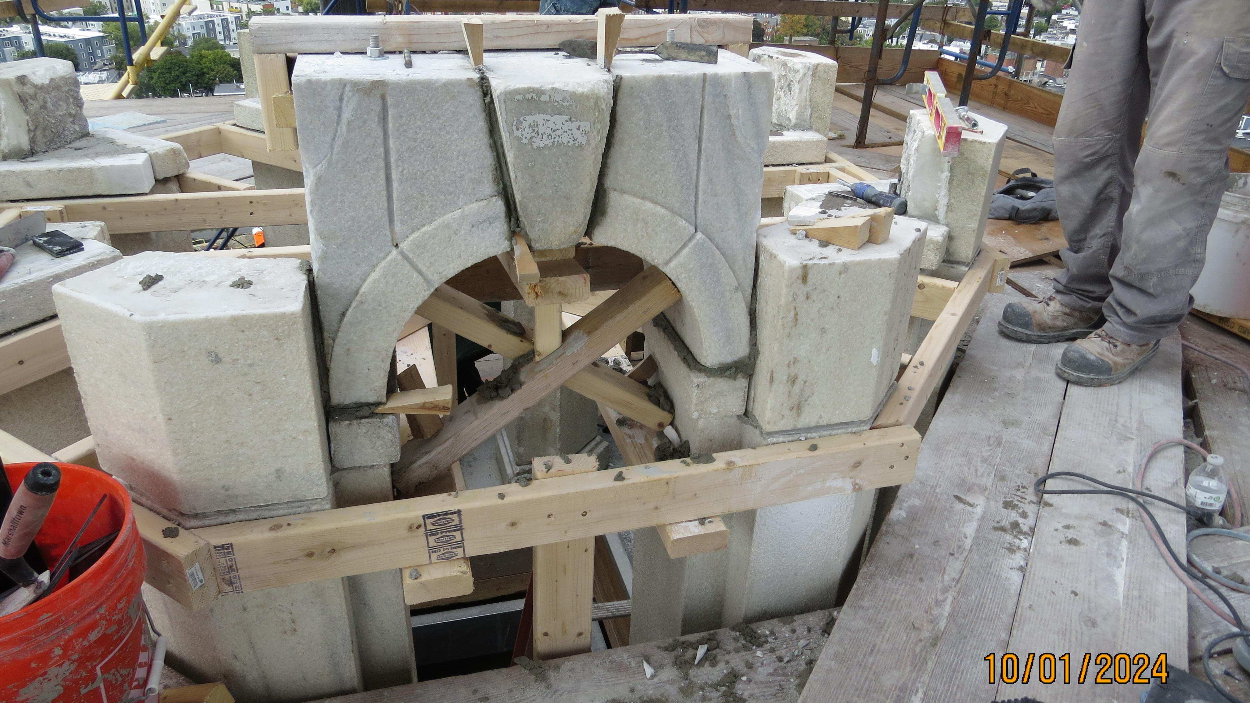 Arched window out of granite being put back together. 