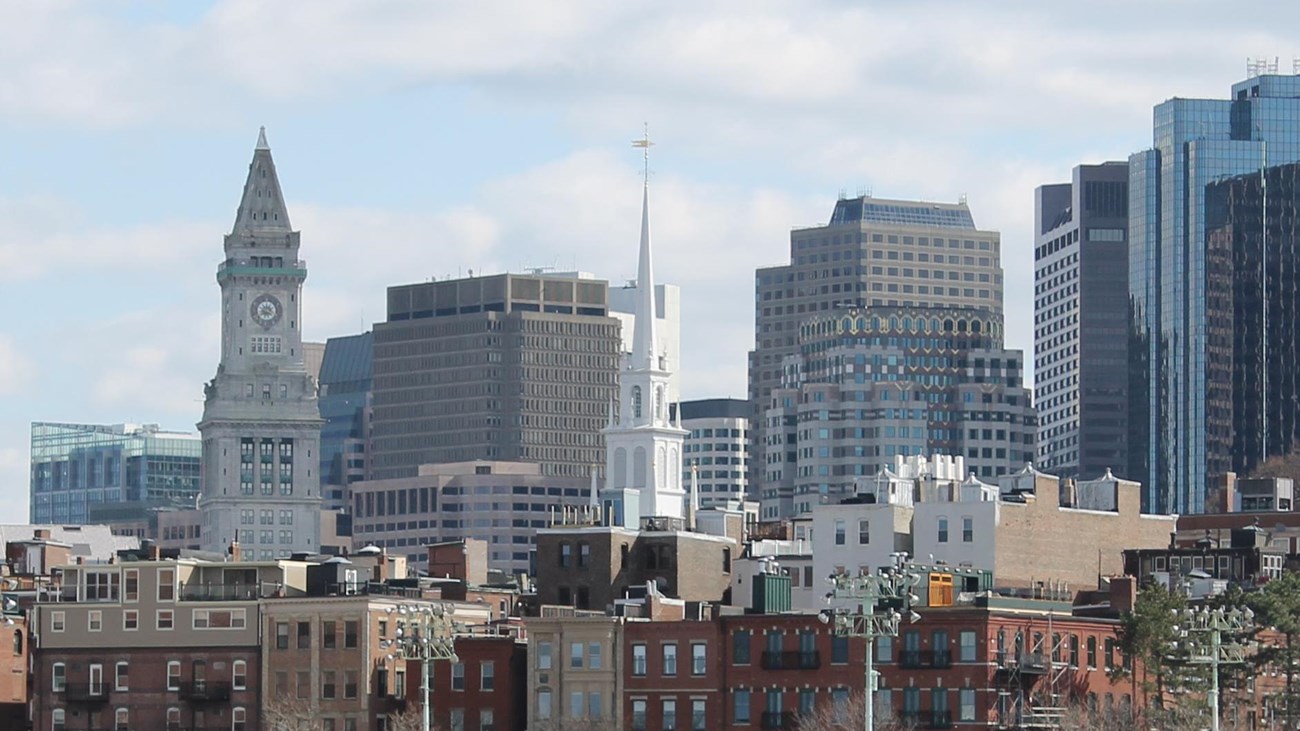 A view of Boston's skyline at daytime. White steeple of Old North in Center.