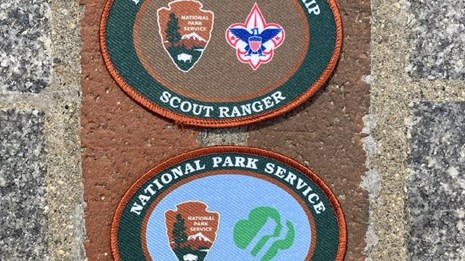 Two scout ranger patches arranged on top of the red brick of the Freedom Trail.