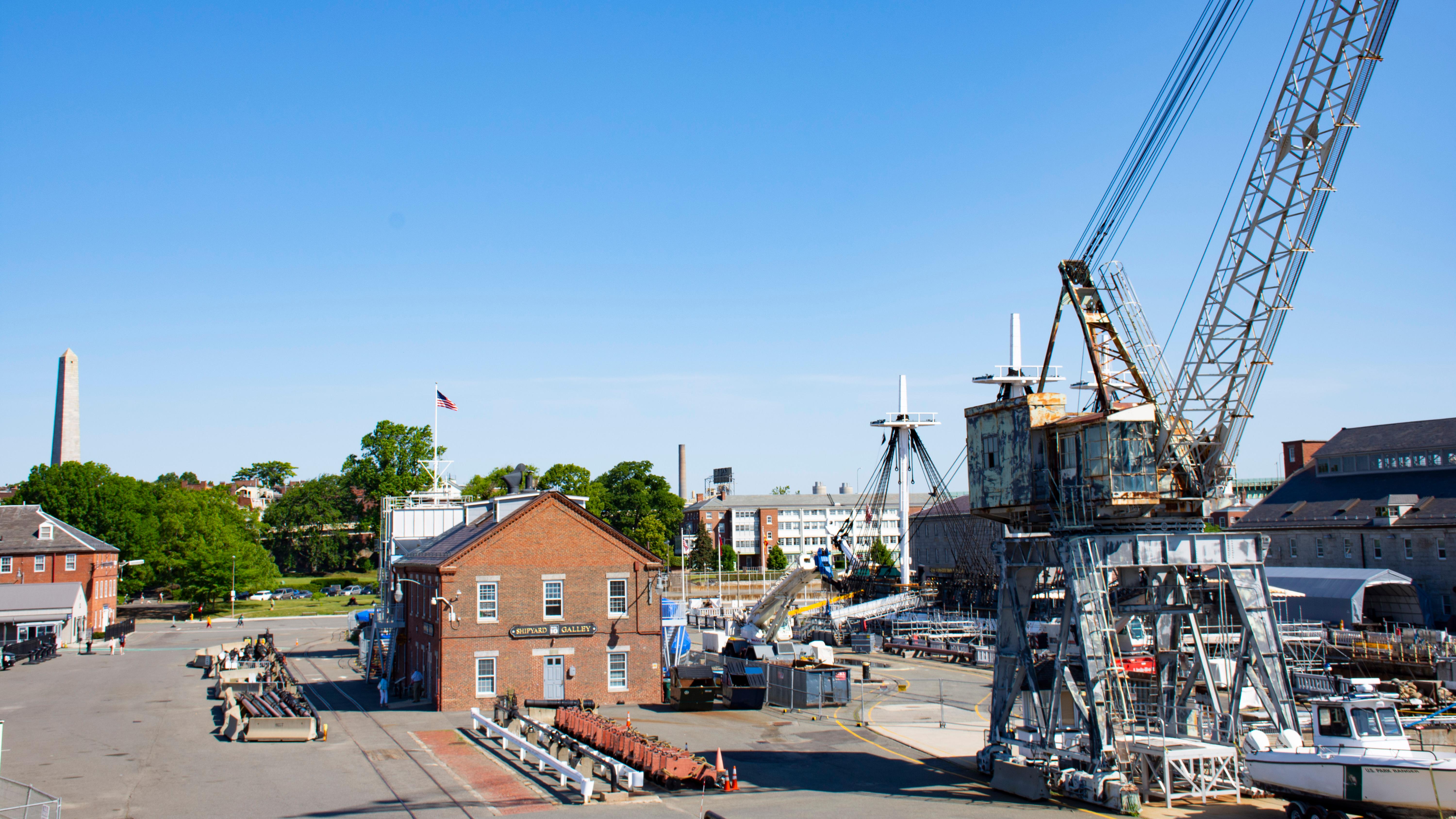 A crane and buildings at a navy yard. 