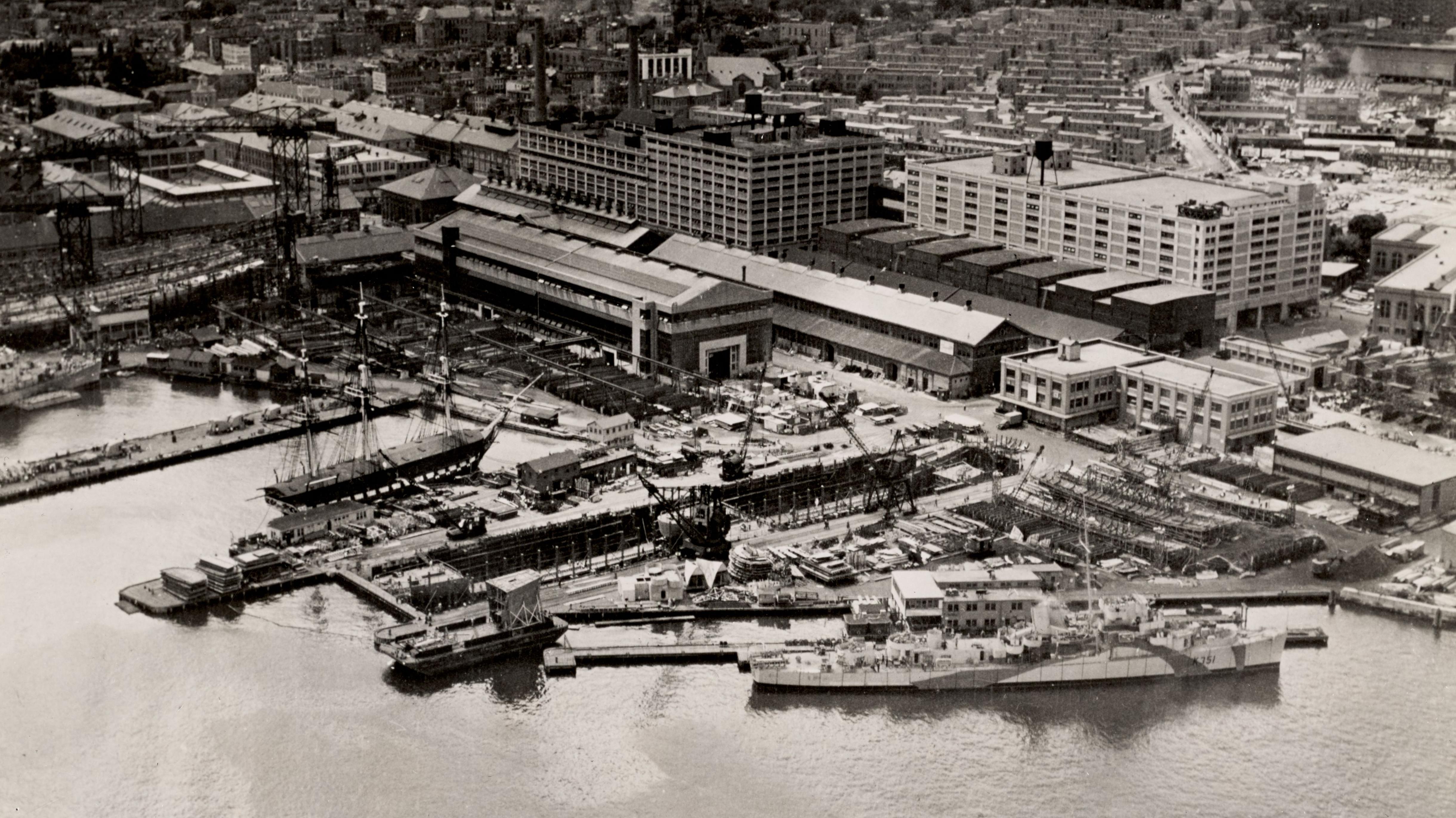 Aerial view of the Charlestown Navy Yard and its piers; USS Constitution is docked at the Navy Yard.