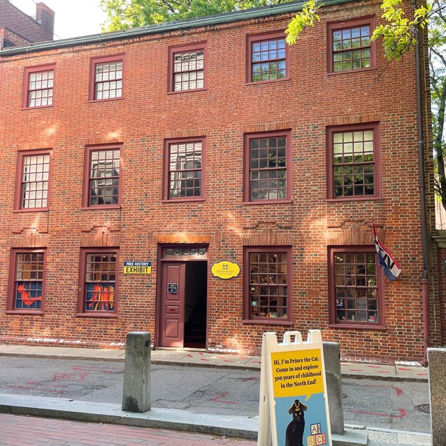 a three-story brick building with paned glass windows