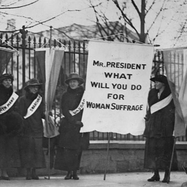 Suffragists standing in a picket line outside the White House.