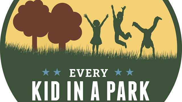 A picture of three children hopping and jumping on a grassy area