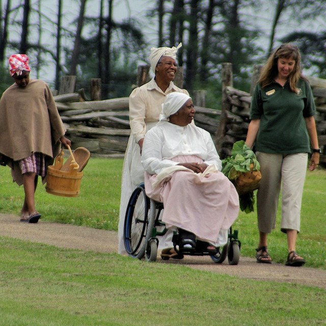 A group of volunteers walking along a path prepare for a presentation. 