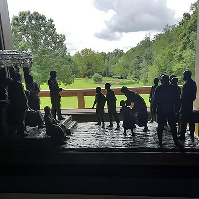 A sculpture depicting the moment of emancipation with the grounds of the Monument in the background.