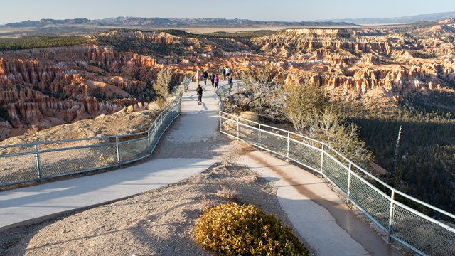 Two paved paths lead out to a viewpoint overlooking the amphitheater filled with red rock formations