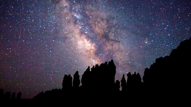 A dark night sky is the backdrop to the bright stars of the milky way.