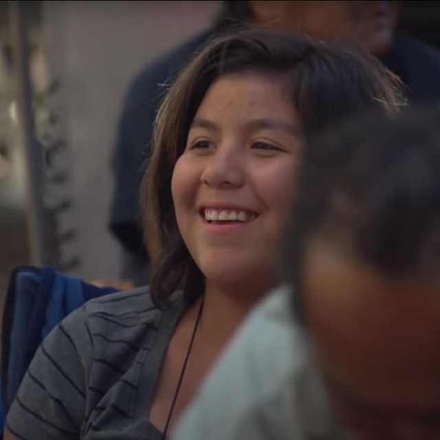 Young girl laughs in camping group