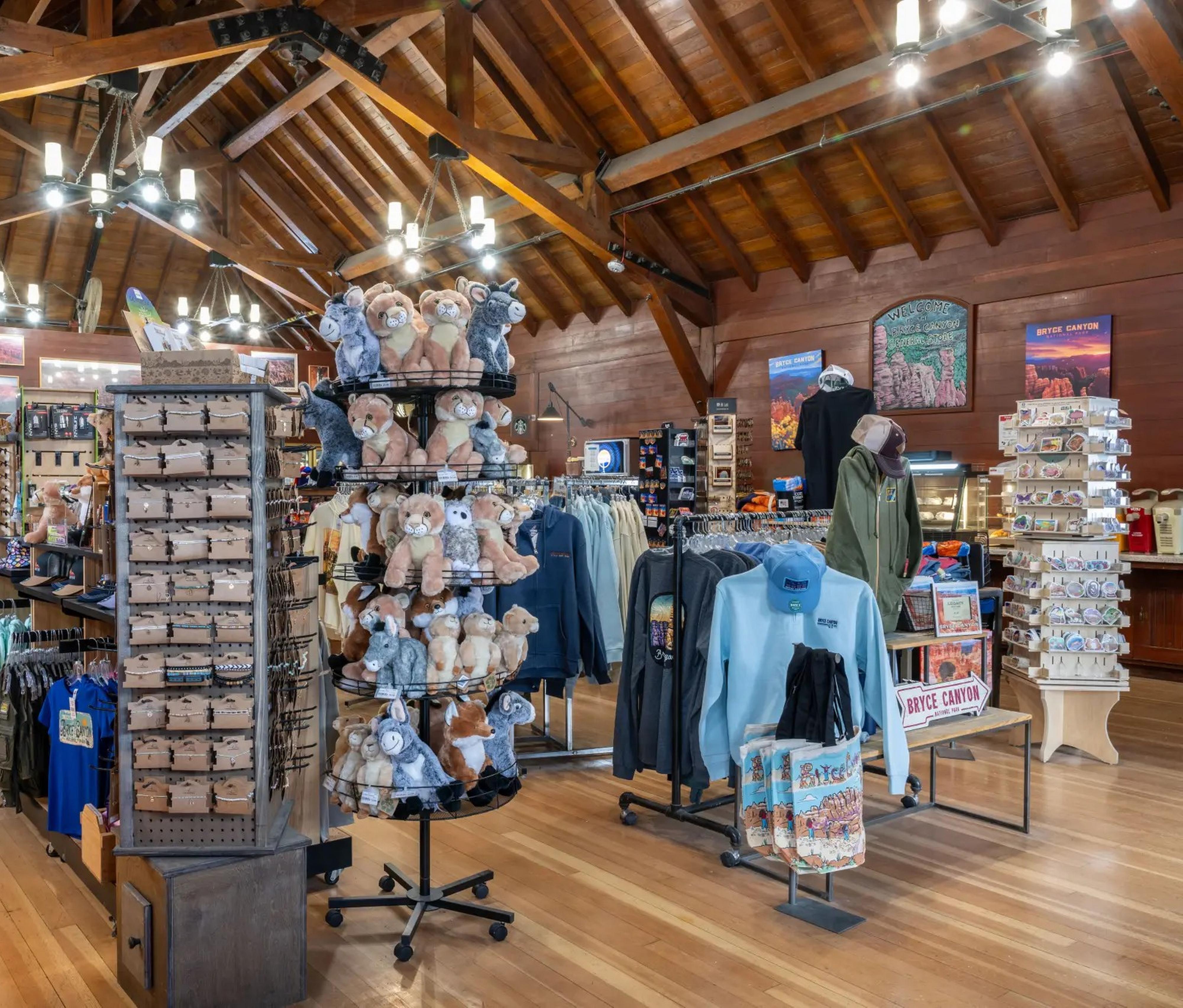 The interior of a wooden building with store displays under chandeliers.