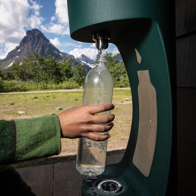 a water bottle filling station is used to refill a water bottle