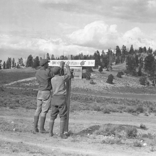 Two boys in black and white photo affix sign reading 