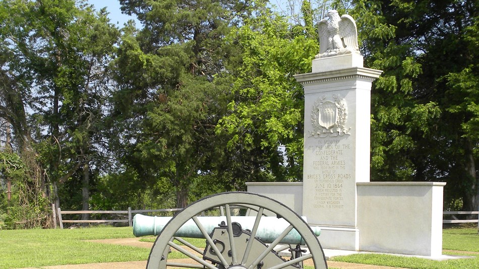 Photo of Brcies Cross Roads Battlefield Monument with a civil war cannon placed in front.