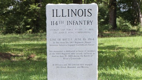 Granite monument with black etched letters. Monument in commemoration of 114th Illinois.