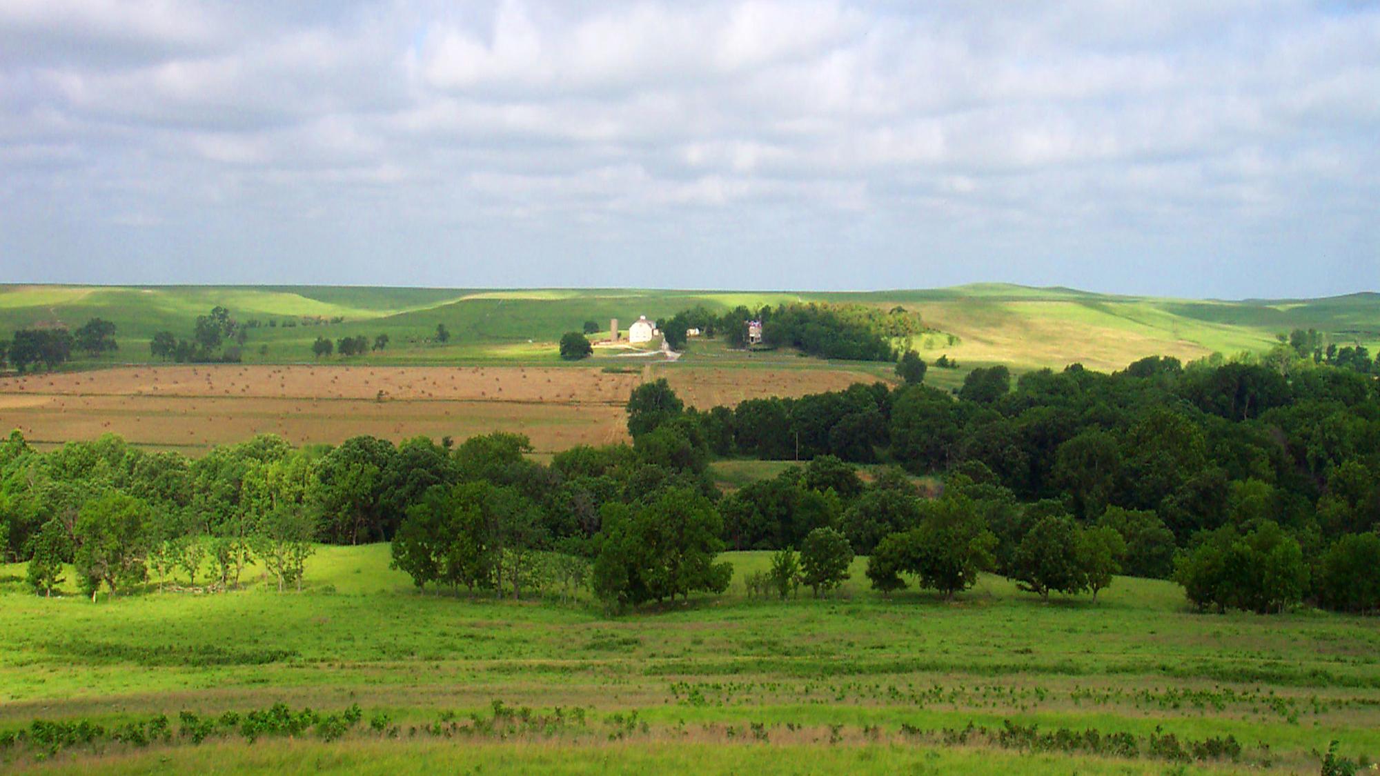 An open field with hills and blue skies.