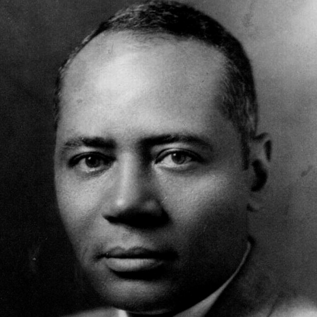 Charles Hamilton Houston poses for a head and shoulders portrait in a grey suit.