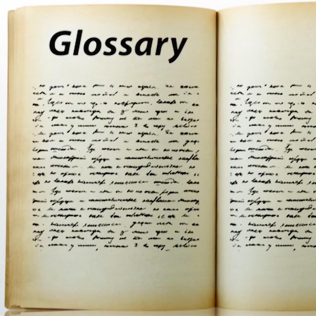 a worn and open book with the word Glossary as a heading and scripted gibberish for content