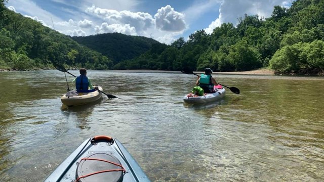 Three paddlers kayaking down the Lower Buffalo River