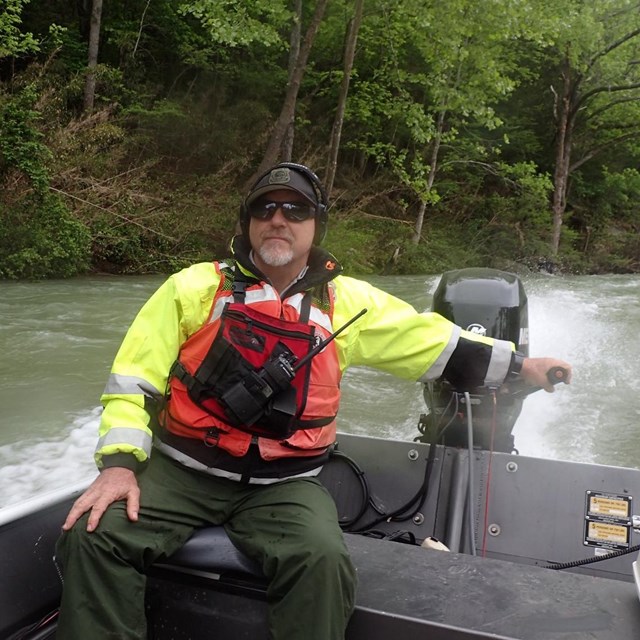 A park ranger operates a boat during a river rescue.