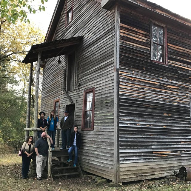 A group stands at the entrance of the historic Boxley Grist Mill.