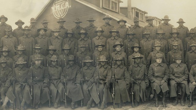 Several african american soldiers stand at attention for company photo