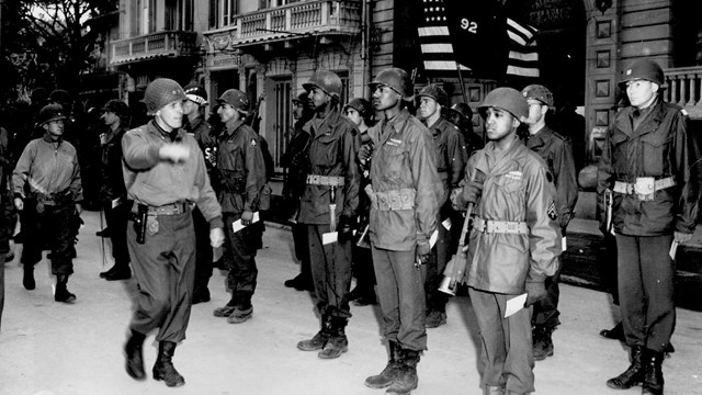 Several african american soldiers posing for a General's review
