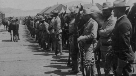 Soldiers standing next to their horses at the Presidio