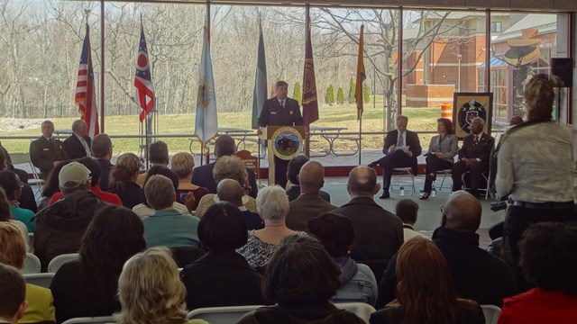 Several people in a room listening to a speaker at an event