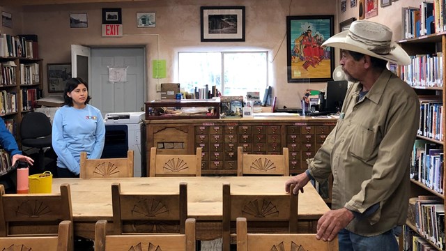 People stand in a small library.