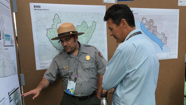A park ranger points at a map.