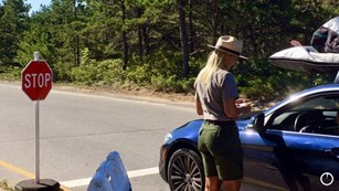 Ranger helps visitor pay entrance fee.
