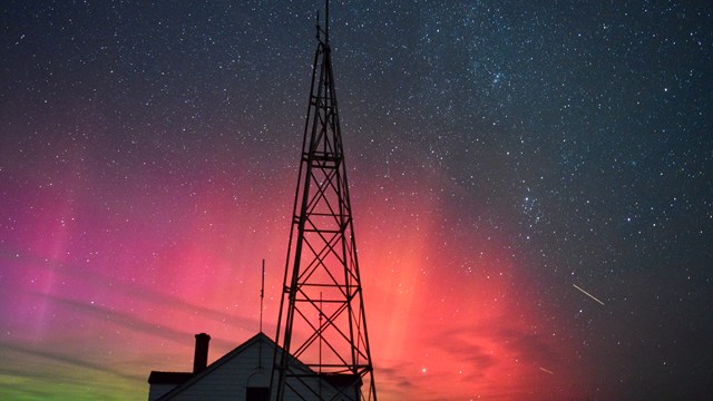Northern Lights shimmering over an old Coast Guard Building.