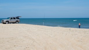 Fisherman on beach with ORV
