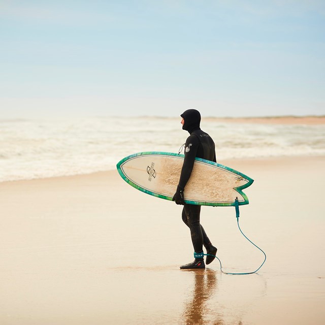 a surfer holding a board walking towards the ocean