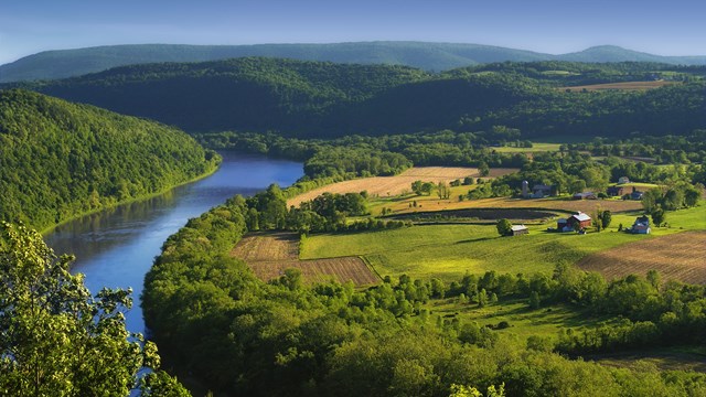 An overlook with view of river and farmland. 