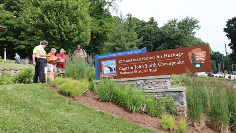 Front sign at the Zimmerman Center for Heritage with people around it.