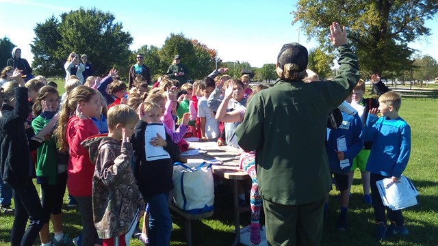 A teacher in front of a class on a field trip. 