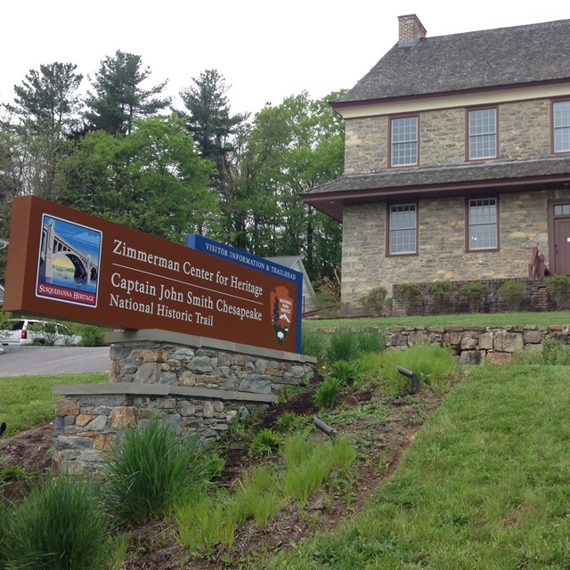 A brick building on a hill with an entrance sign