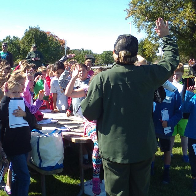 A teacher in front of a class on a field trip. 