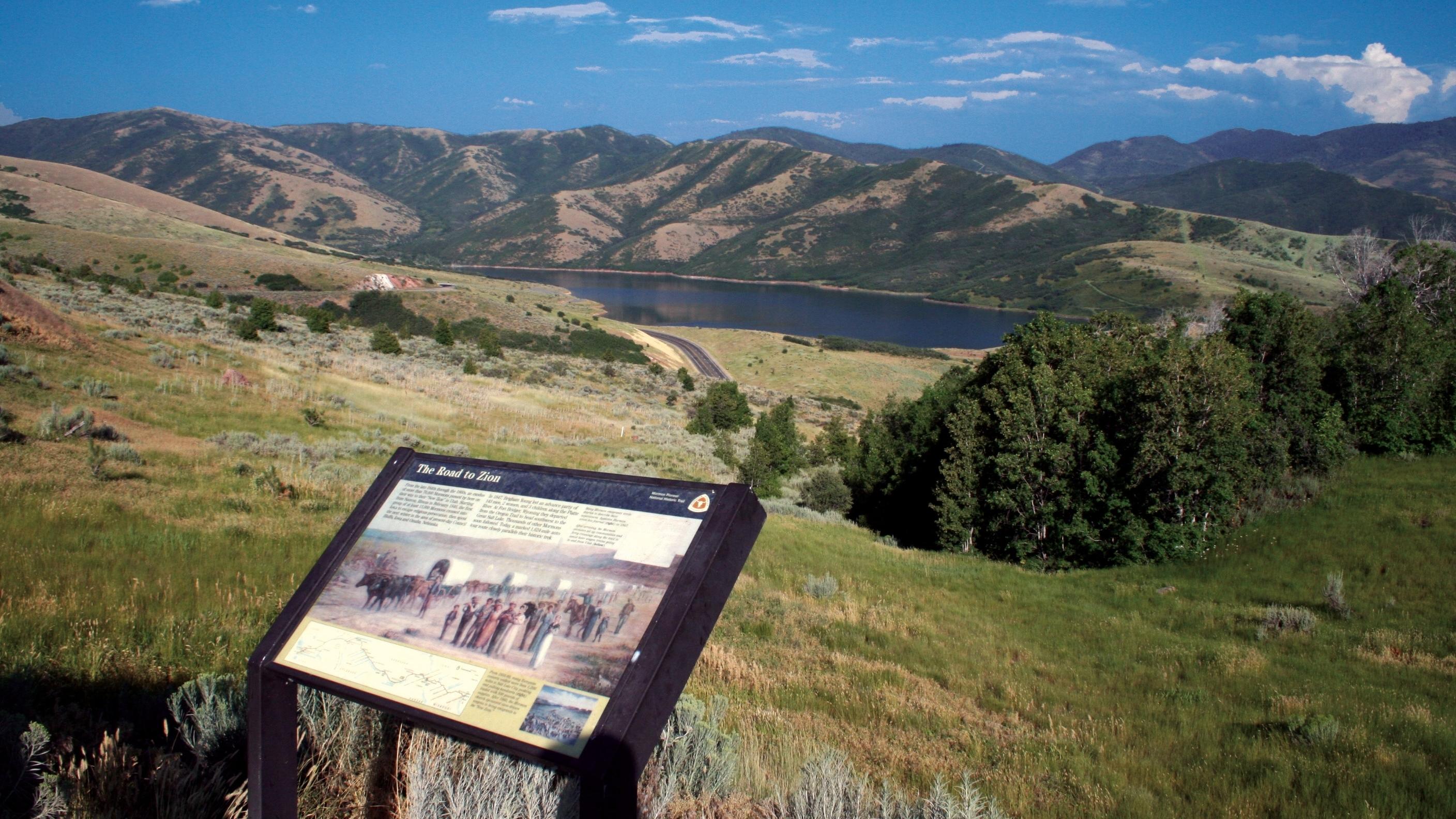 An exhibit sign in front of an expansive view of a canyon.