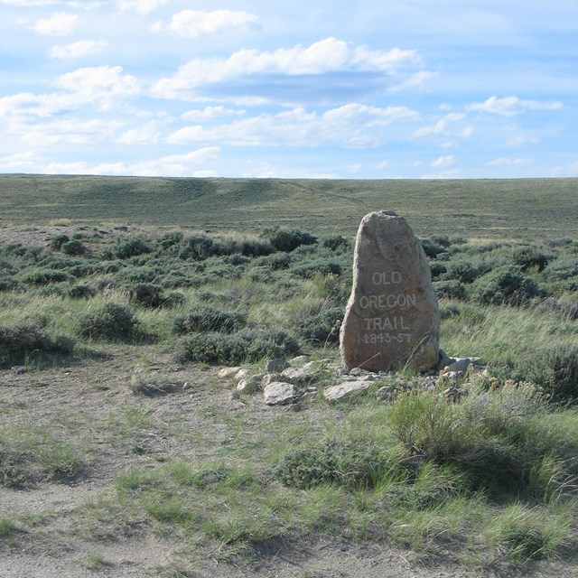 A stone marker in a large open field.