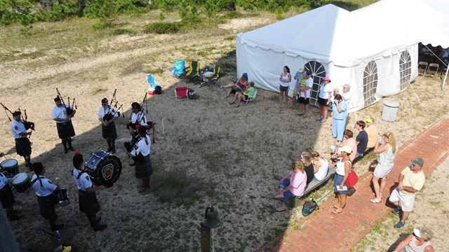 Aerial view of a crowd next to the Lighthouse. A white ten is set up in top right.