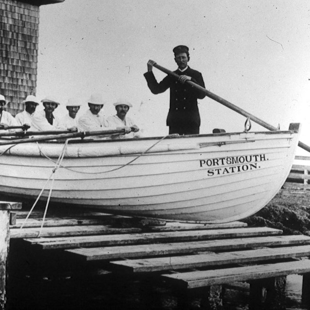 The crew of the Portsmouth Life-Saving Station demonstrates the launch of a rescue surfboat.
