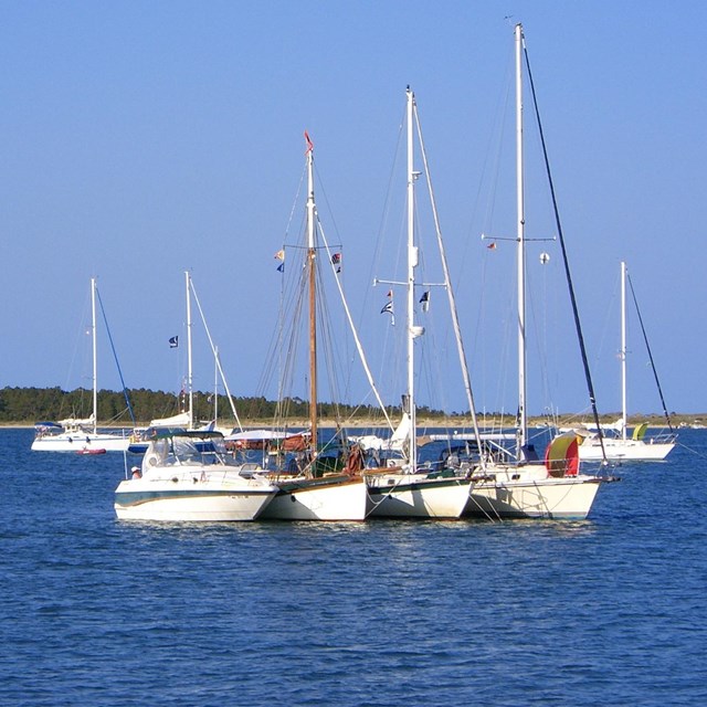 A variety of boats anchor offshore at Cape Lookout National Seashore.