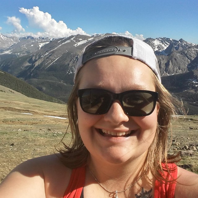 A selfie of Allie with mountains in the background at Rocky Mountain National Park