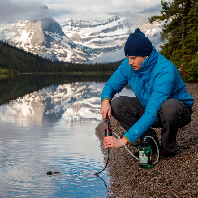 A man filters water from a mountain stream