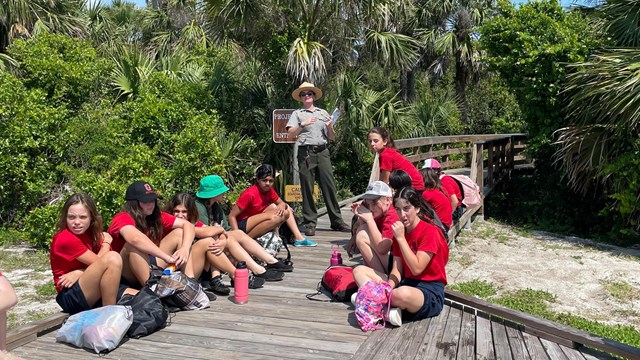 A class smiles for a photo while at a beach program.