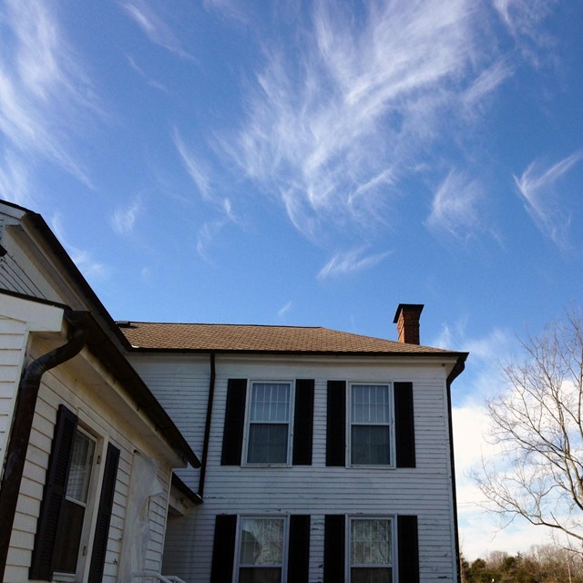 Clouds swirl in sky above Oliver Perry House