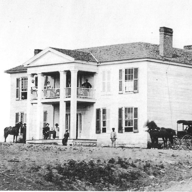Two-story building with people outside on porch and upstairs balconies during the Civil War.