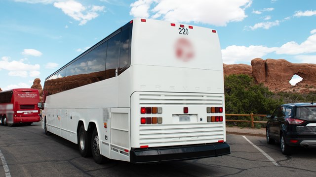 A large white bus in a parking area.